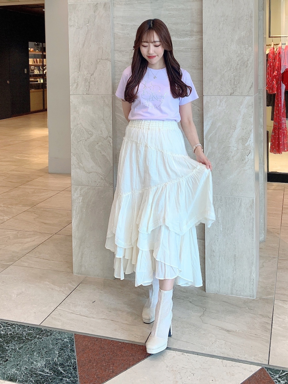 ホワイト系のブーツ、ピンク系のTシャツ/カットソー、イエロー系のスカートを着用したレディースの春コーディネートの3枚目の写真