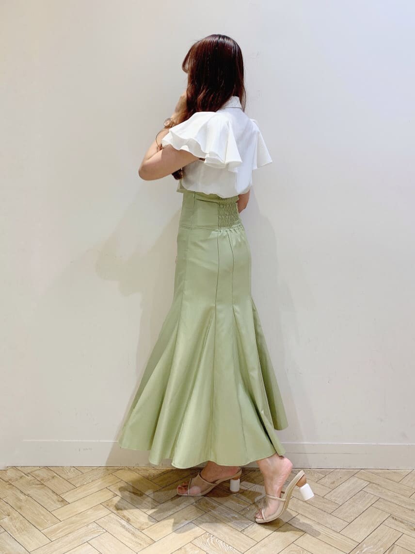 ホワイト系のシャツ/ブラウス、グリーン系のスカート、ベージュ系のサンダルを着用したレディースの夏コーディネートの2枚目の写真