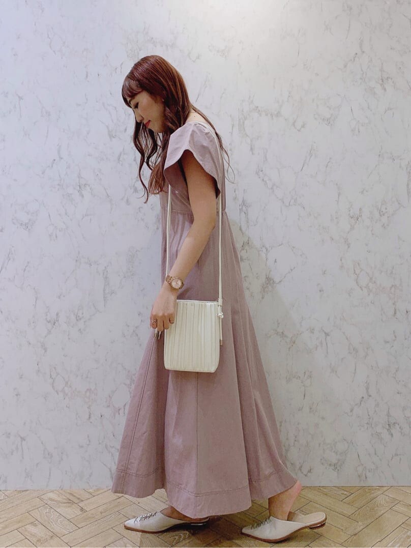ベージュ系のワンピース、ホワイト系のサンダル、ホワイト系のハンドバッグを着用したレディースの夏コーディネートの3枚目の写真