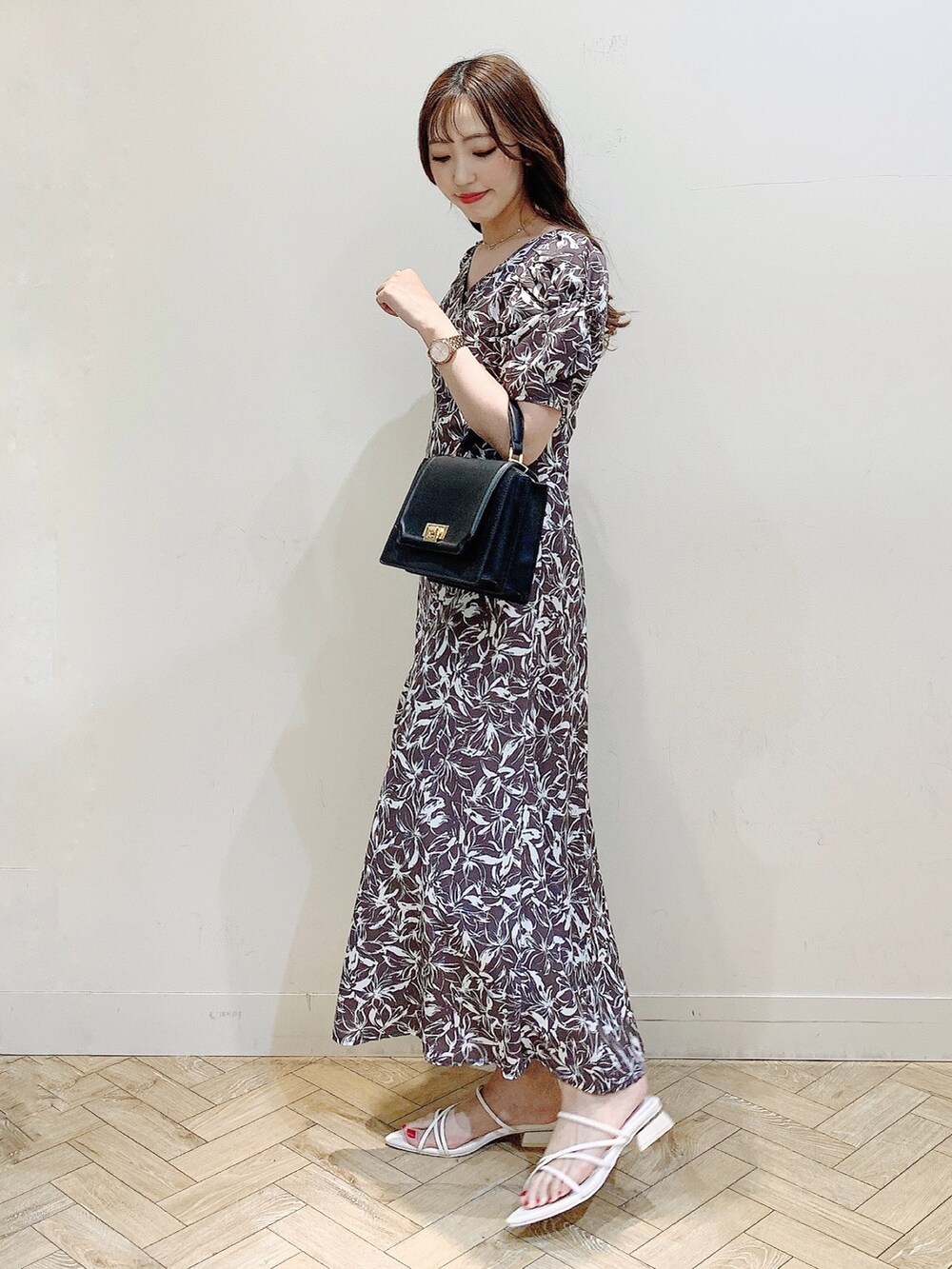 グレー系のワンピース、ホワイト系のサンダル、ブラック系のハンドバッグを着用したレディースの春コーディネートの5枚目の写真