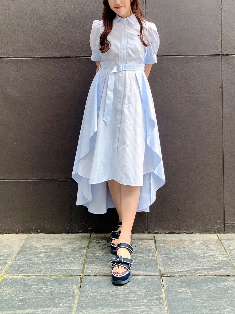 ブルー系のワンピースを着用したレディースの春コーディネートの2枚目の写真