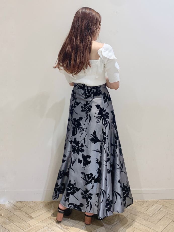 グレー系のスカート、ブラック系のサンダル、ホワイト系のニット/セーターを着用したレディースの夏コーディネートの6枚目の写真