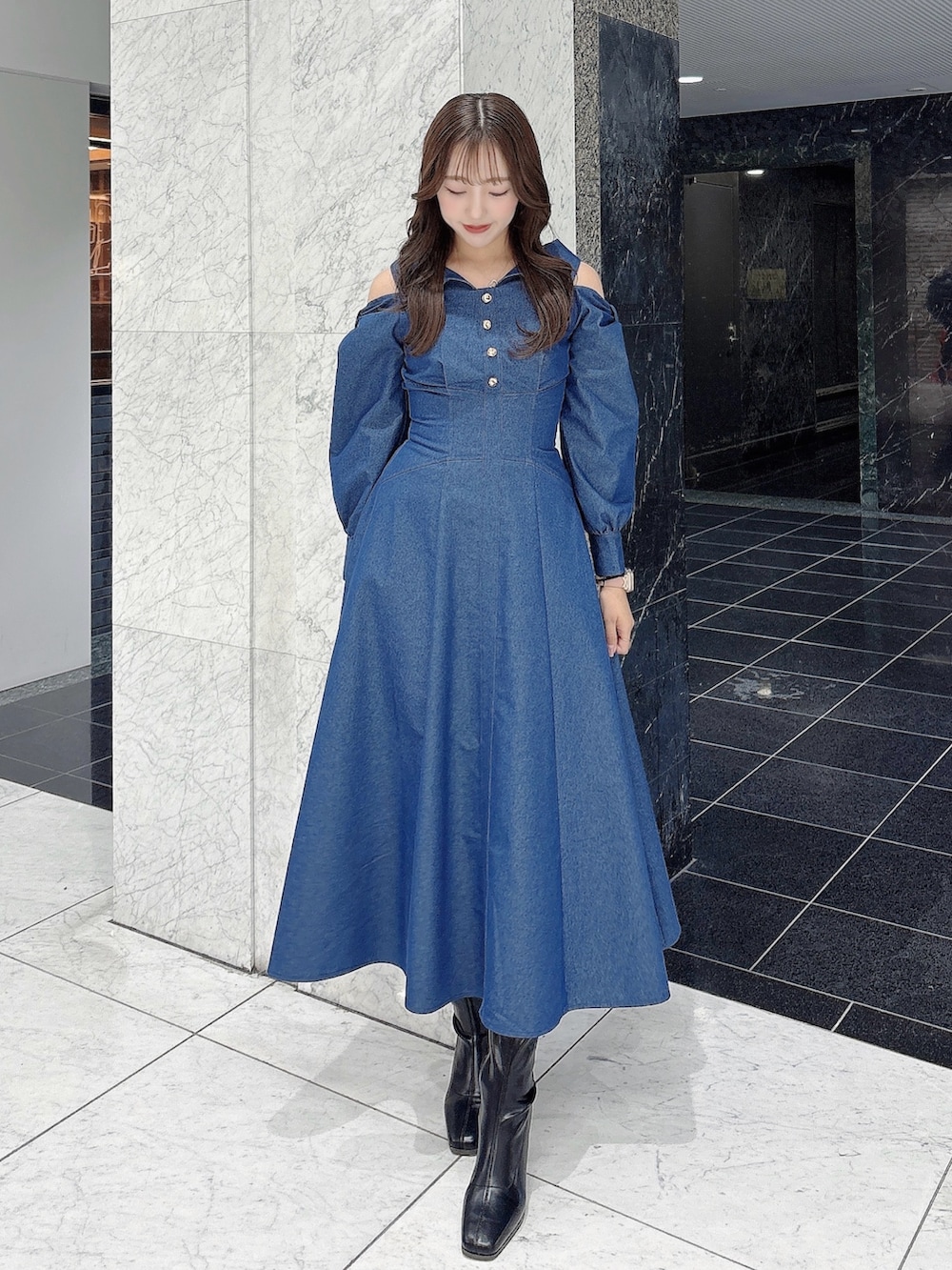 ブルー系のワンピース、ブラック系のブーツを着用したレディースの冬コーディネートの3枚目の写真