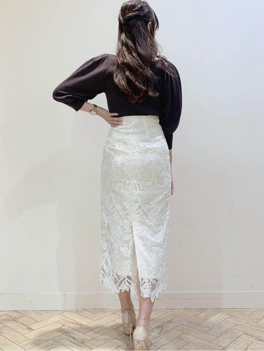 ベージュ系のパンプス、ホワイト系のスカート、ベージュ系のトレンチコートを着用したレディースの春コーディネートの3枚目の写真