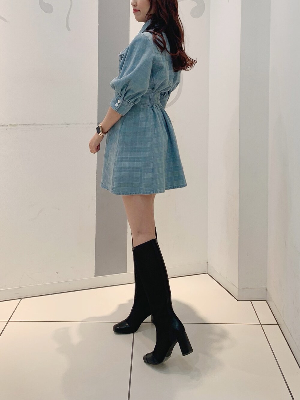 ブルー系のシャツワンピース、ブラック系のブーツを着用したレディースの冬コーディネートの5枚目の写真