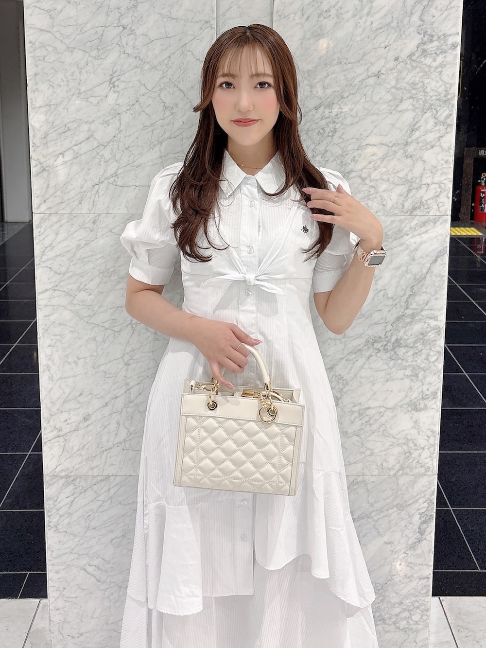 ホワイト系のワンピース、ホワイト系のパンプス、ホワイト系のハンドバッグを着用したレディースの春コーディネートの8枚目の写真