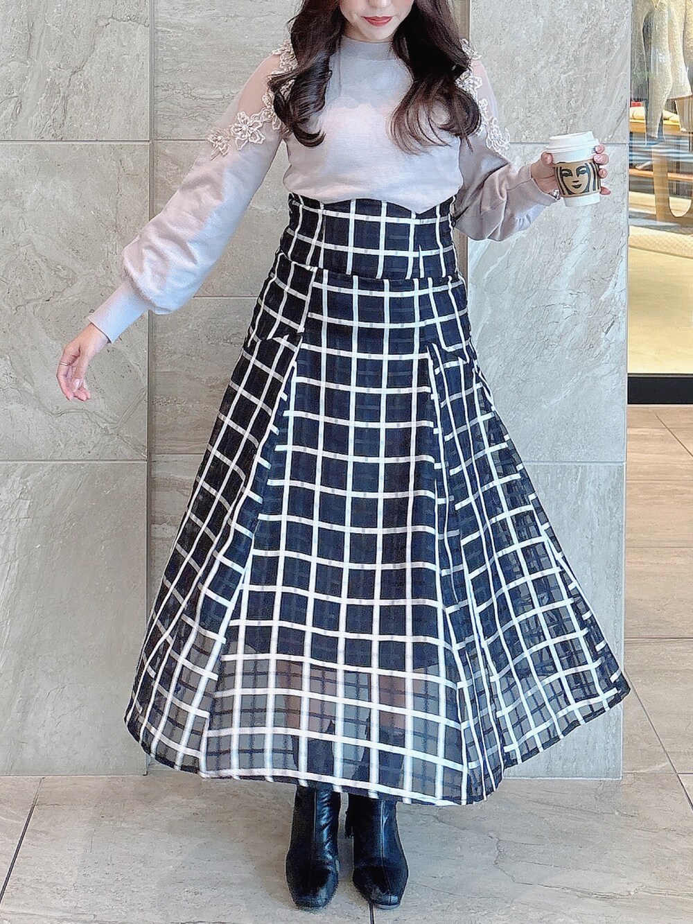 ブラック系のブーツ、ブラック系のスカート、ピンク系のニット/セーターを着用したレディースの冬コーディネートの4枚目の写真