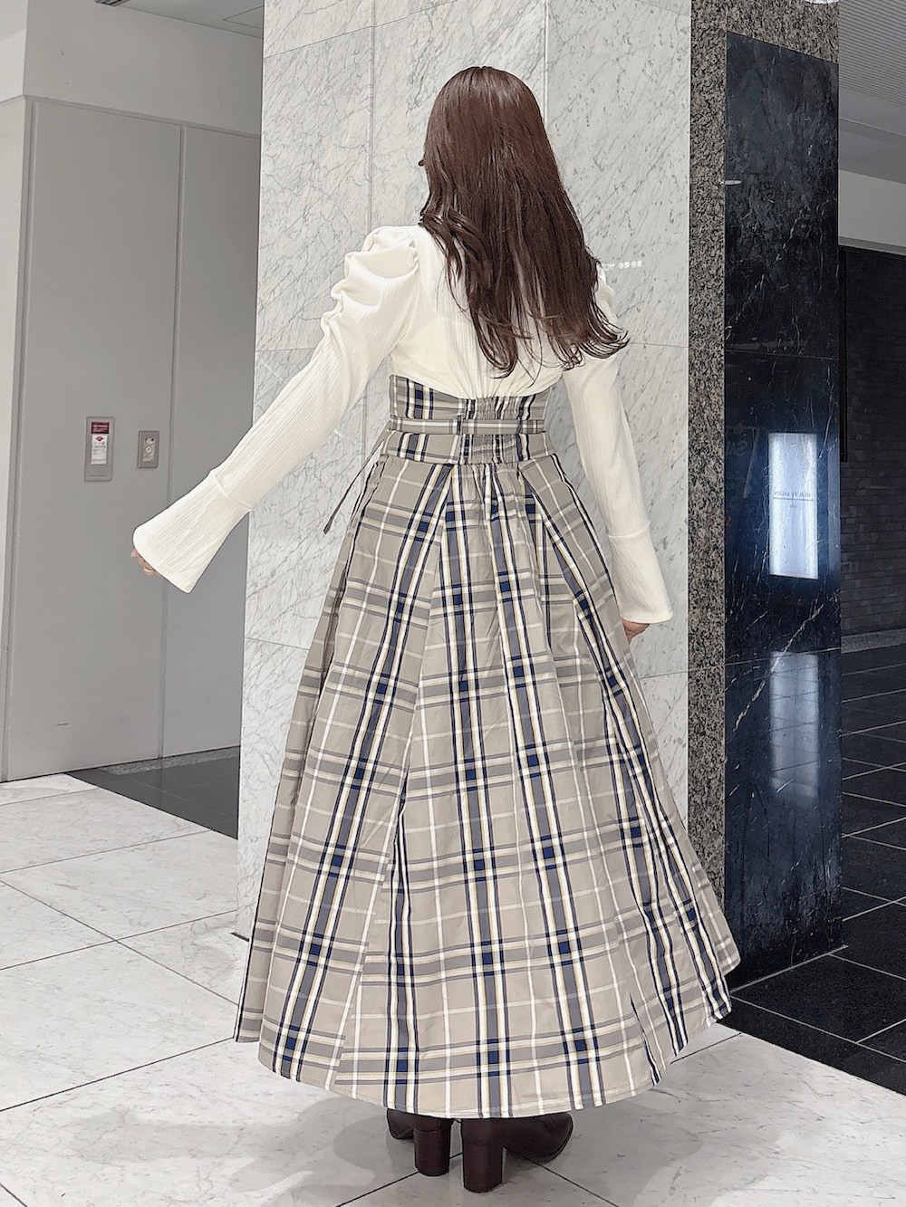 ホワイト系のワンピース、ブラウン系のブーツを着用したレディースの秋コーディネートの4枚目の写真