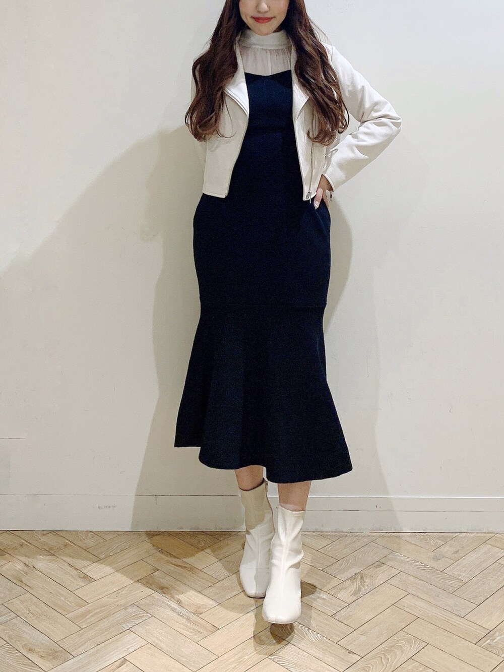 ブラック系のワンピース、ホワイト系のブーツ、ベージュ系のライダースジャケットを着用したレディースの冬コーディネートの4枚目の写真