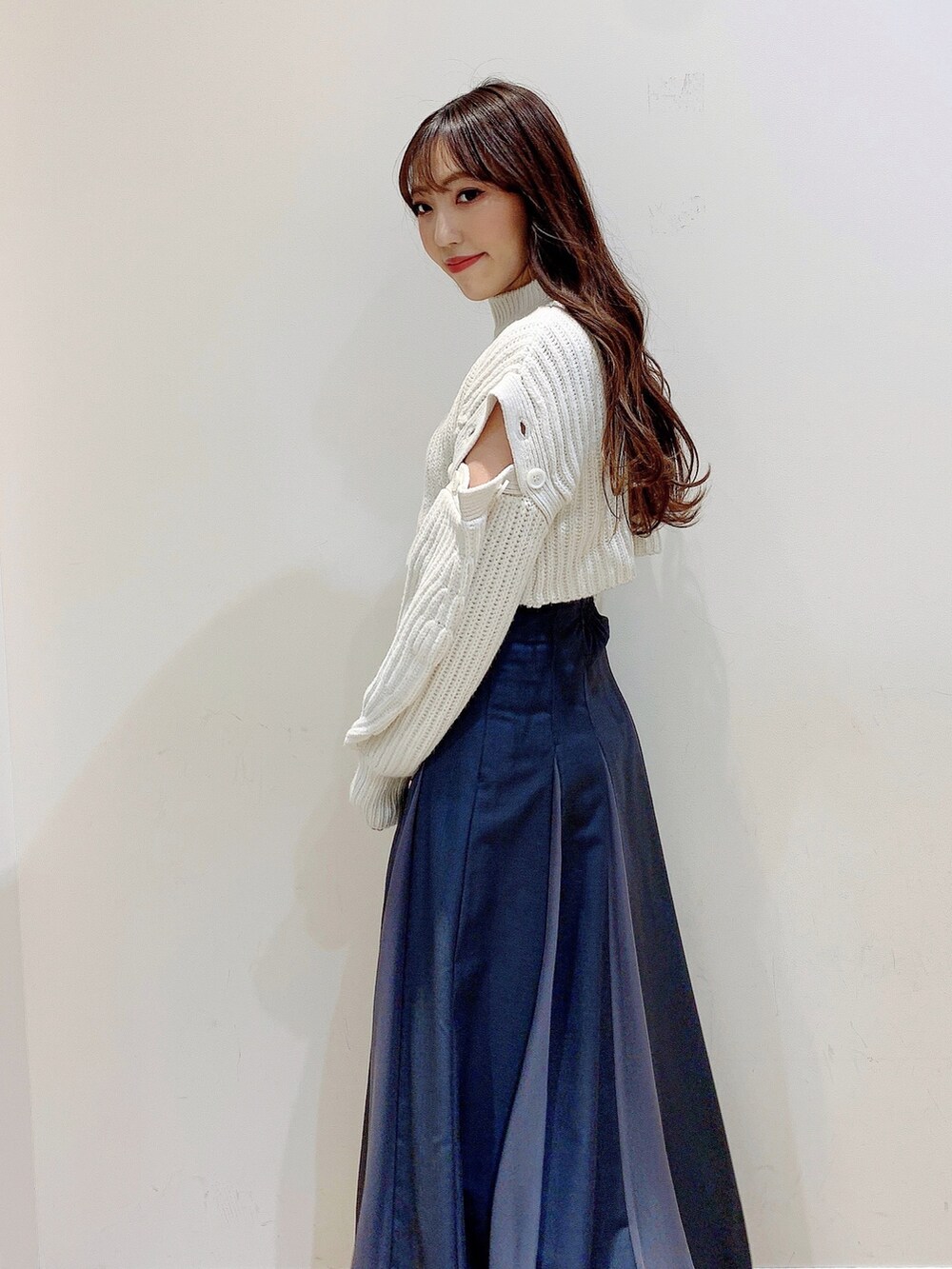 グレー系のスカート、ホワイト系のワンピース、ブラウン系のブーツを着用したレディースの冬コーディネートの7枚目の写真