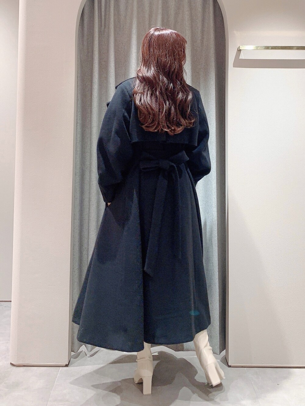 ホワイト系のワンピース、ホワイト系のブーツ、ブラック系のその他アウターを着用したレディースの冬コーディネートの7枚目の写真