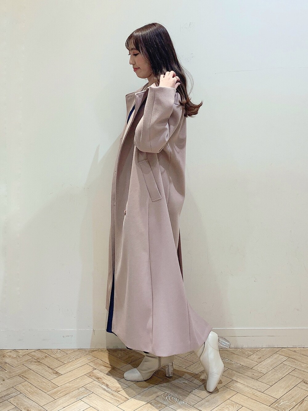 ブルー系のワンピース、ホワイト系のブーツ、ベージュ系のステンカラーコートを着用したレディースの冬コーディネートの6枚目の写真