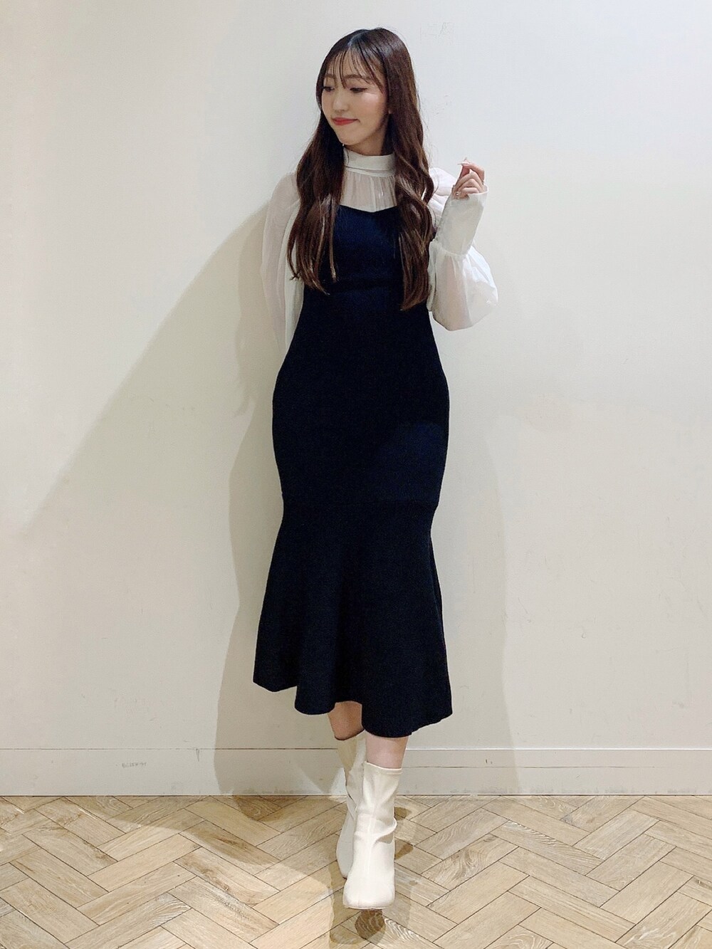 ブラック系のワンピース、ホワイト系のブーツを着用したレディースの冬コーディネートの2枚目の写真