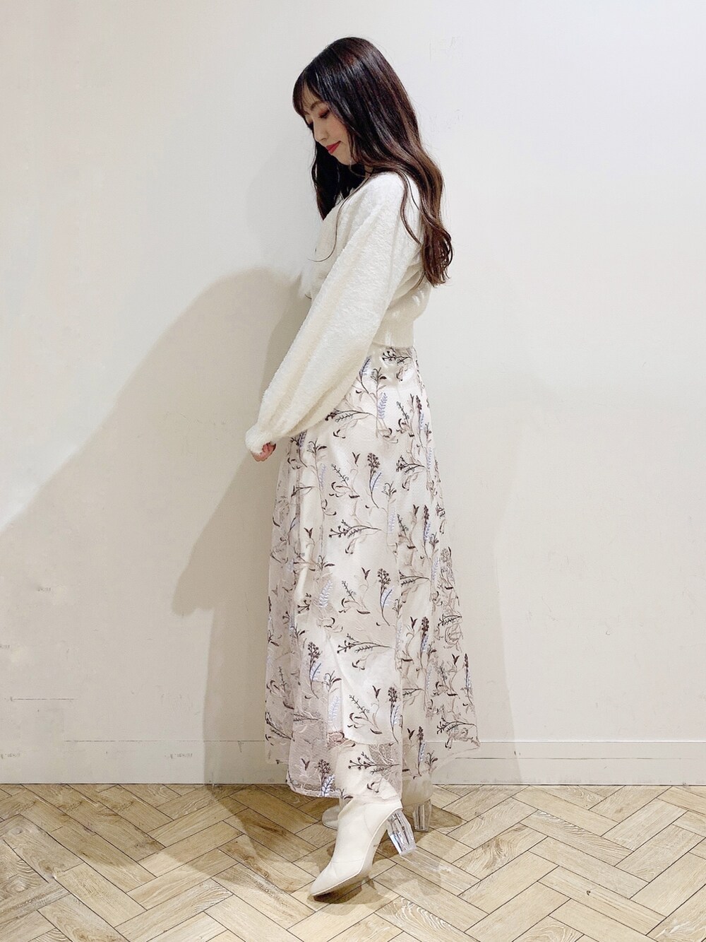 ピンク系のスカート、ホワイト系のカーディガン/ボレロ、ホワイト系のブーツを着用したレディースの秋コーディネートの4枚目の写真