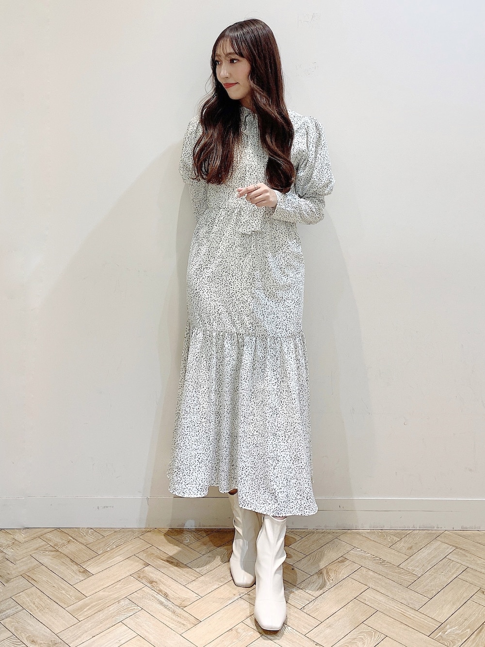 ホワイト系のワンピース、ブラウン系のダウンジャケット/コート、ホワイト系のブーツを着用したレディースの冬コーディネートの3枚目の写真