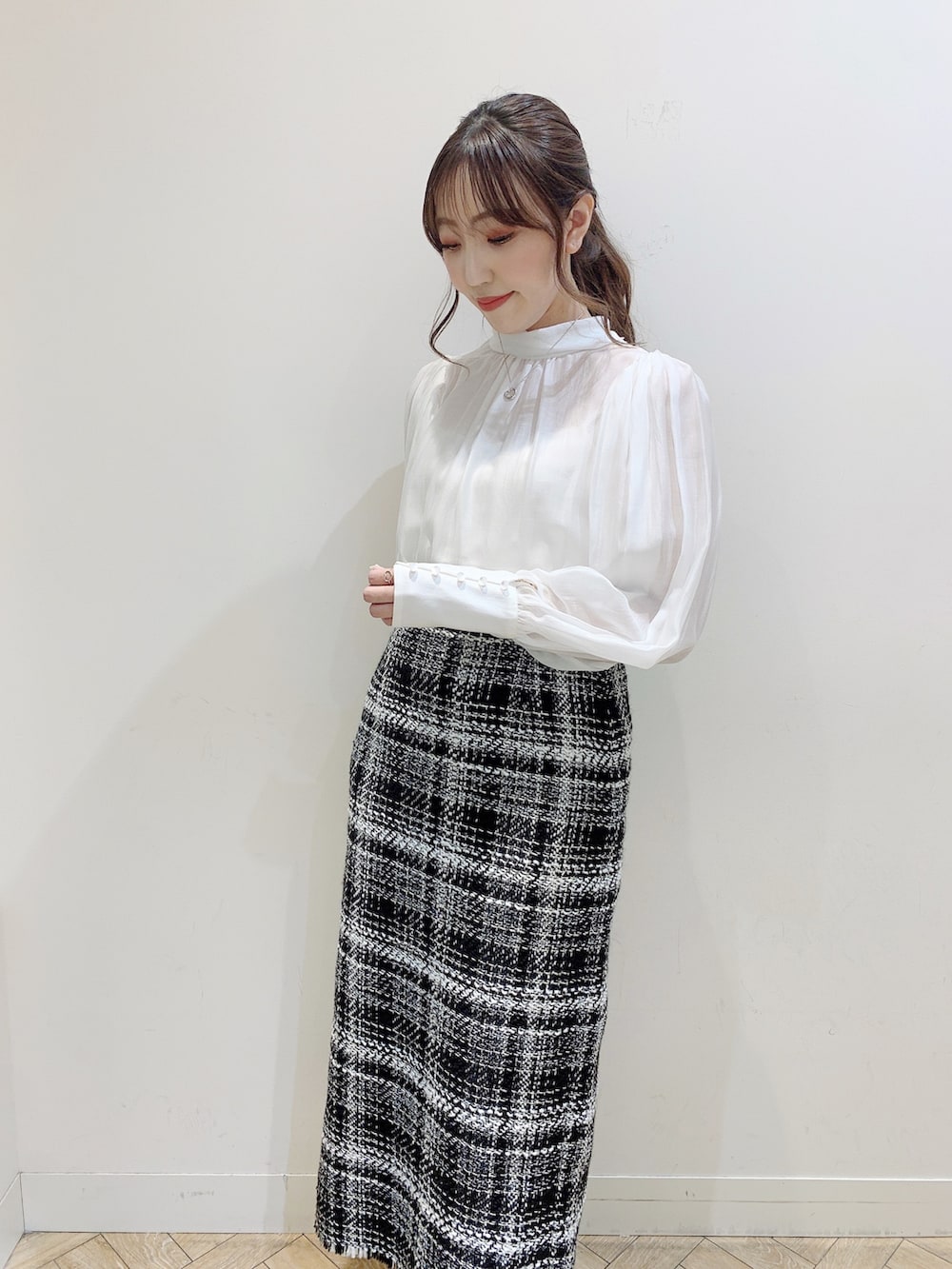 ブラック系のダウンジャケット/コート、ホワイト系のシャツ/ブラウス、ブラック系のスカートを着用したレディースの冬コーディネートの7枚目の写真