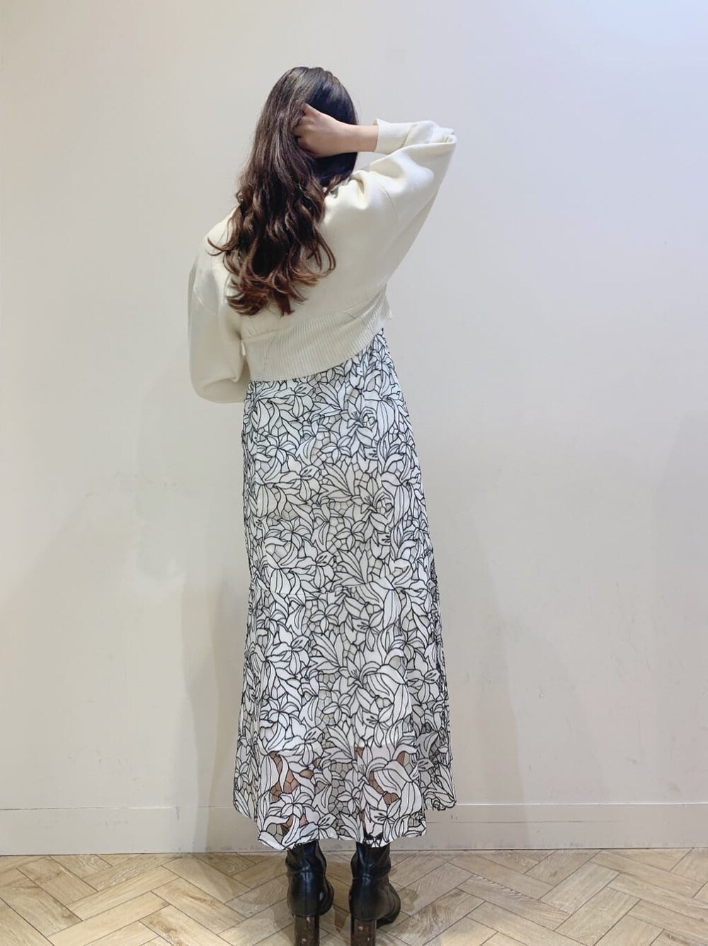 ブルー系のテーラードジャケット、ホワイト系のニット/セーター、ブラック系のワンピースを着用したレディースの春コーディネートの3枚目の写真