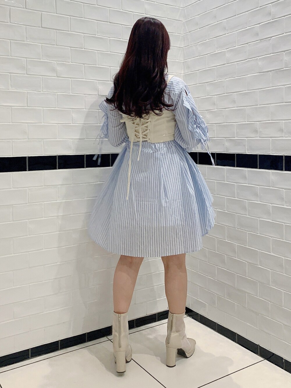 ブルー系のシャツワンピース、ホワイト系のブーツ、ホワイト系のキャミソールを着用したレディースの春コーディネートの5枚目の写真