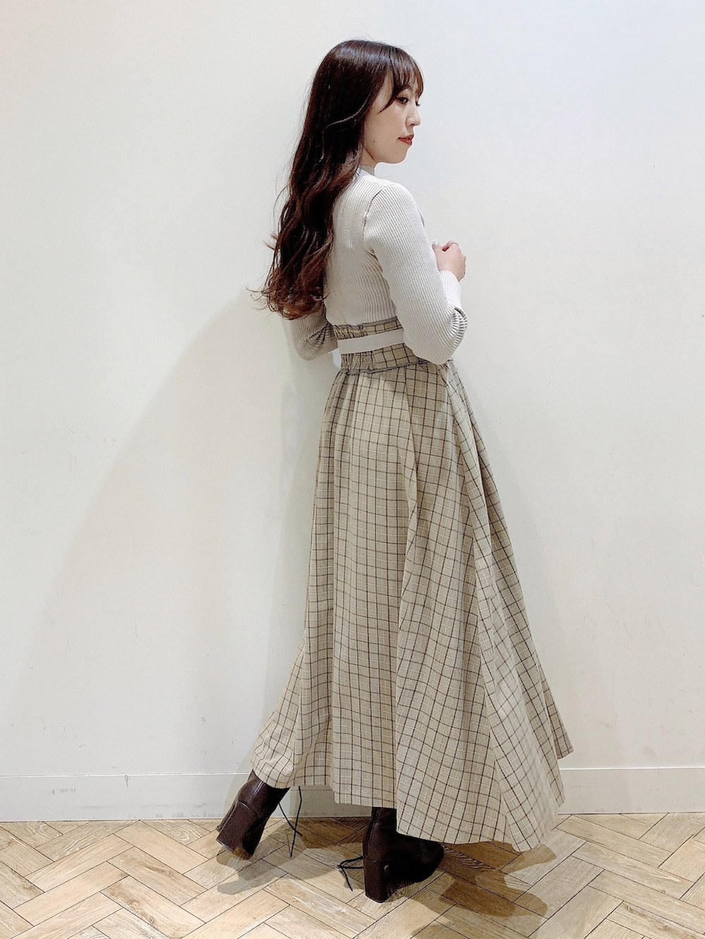 ブラウン系のチェスターコート、ブラウン系のブーツ、ベージュ系のワンピースを着用したレディースの冬コーディネートの4枚目の写真