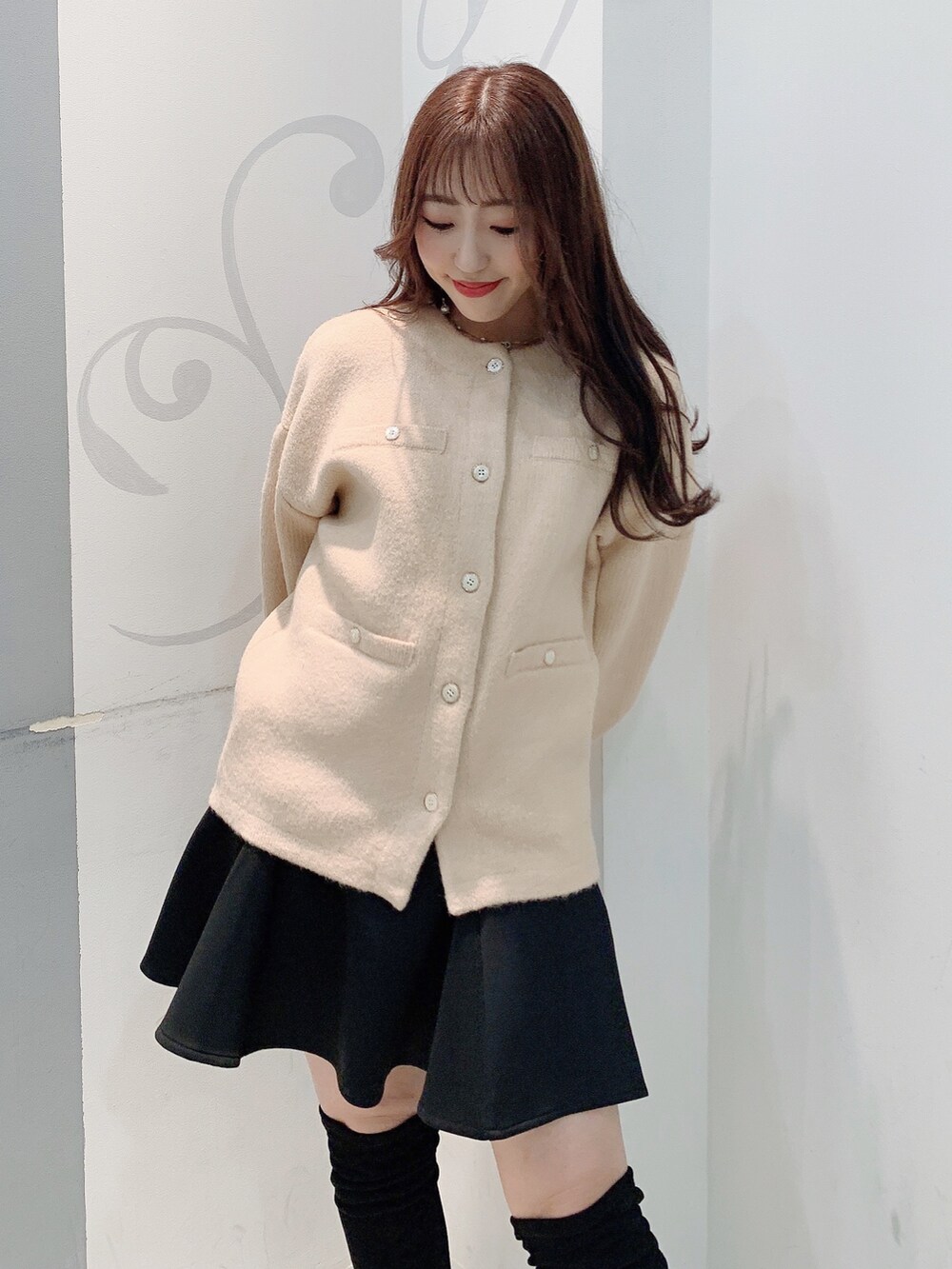 ベージュ系のカーディガン/ボレロ、ブラック系のスカートを着用したレディースの秋コーディネートの5枚目の写真