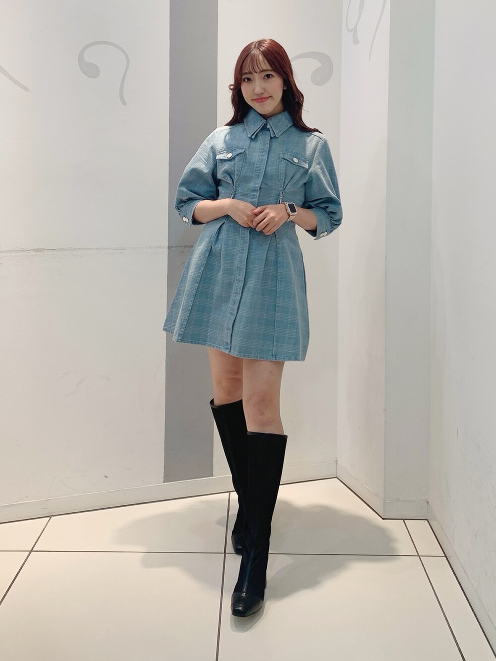 ブルー系のシャツワンピース、ブラック系のブーツを着用したレディースの冬コーディネートの2枚目の写真