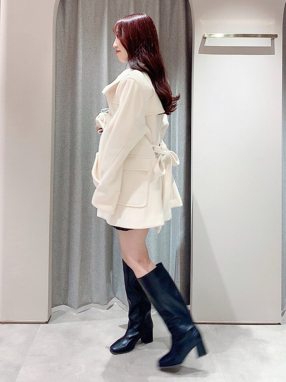 ホワイト系のダッフルコート、ホワイト系のニット/セーター、ブラック系のスカートを着用したレディースの秋コーディネートの4枚目の写真