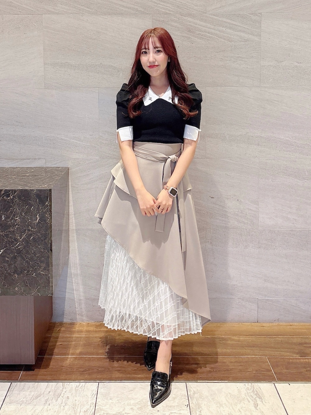 ベージュ系のスカート、その他のニット/セーター、ブラック系のローファーを着用したレディースの春コーディネートの2枚目の写真