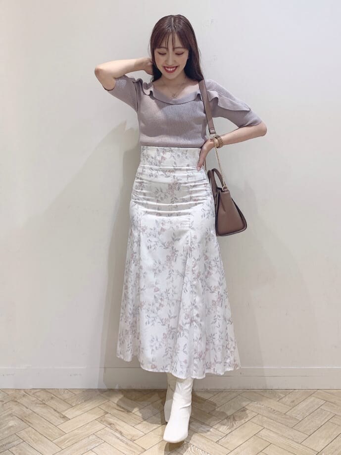 ホワイト系のブーツ、ブラウン系のハンドバッグ、ベージュ系のニット/セーターを着用したレディースの夏コーディネートの2枚目の写真