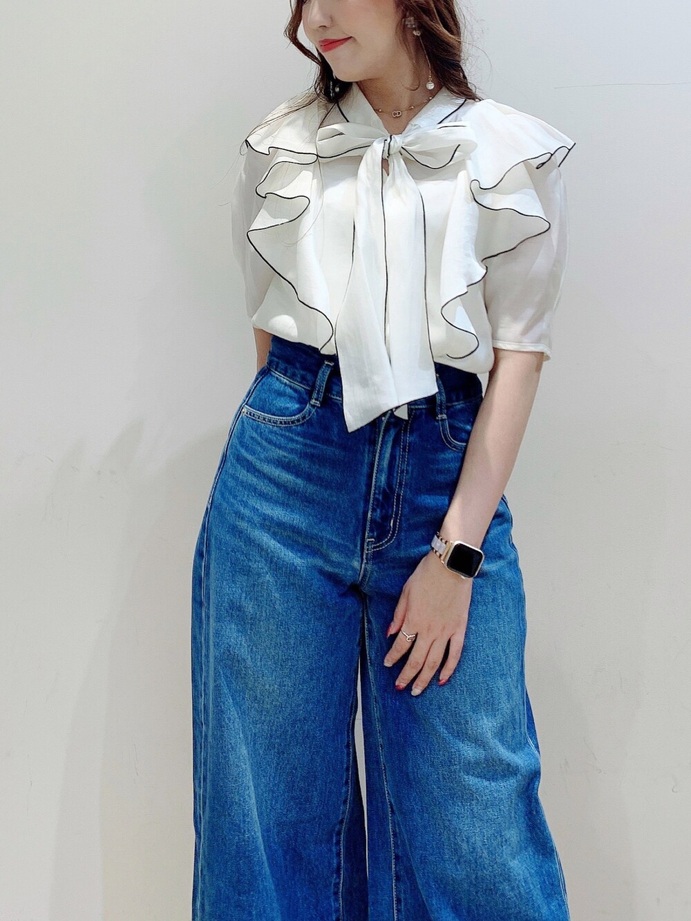 ホワイト系のシャツ/ブラウス、ブラウン系のブーツ、ブルー系のデニムパンツを着用したレディースの夏コーディネートの7枚目の写真