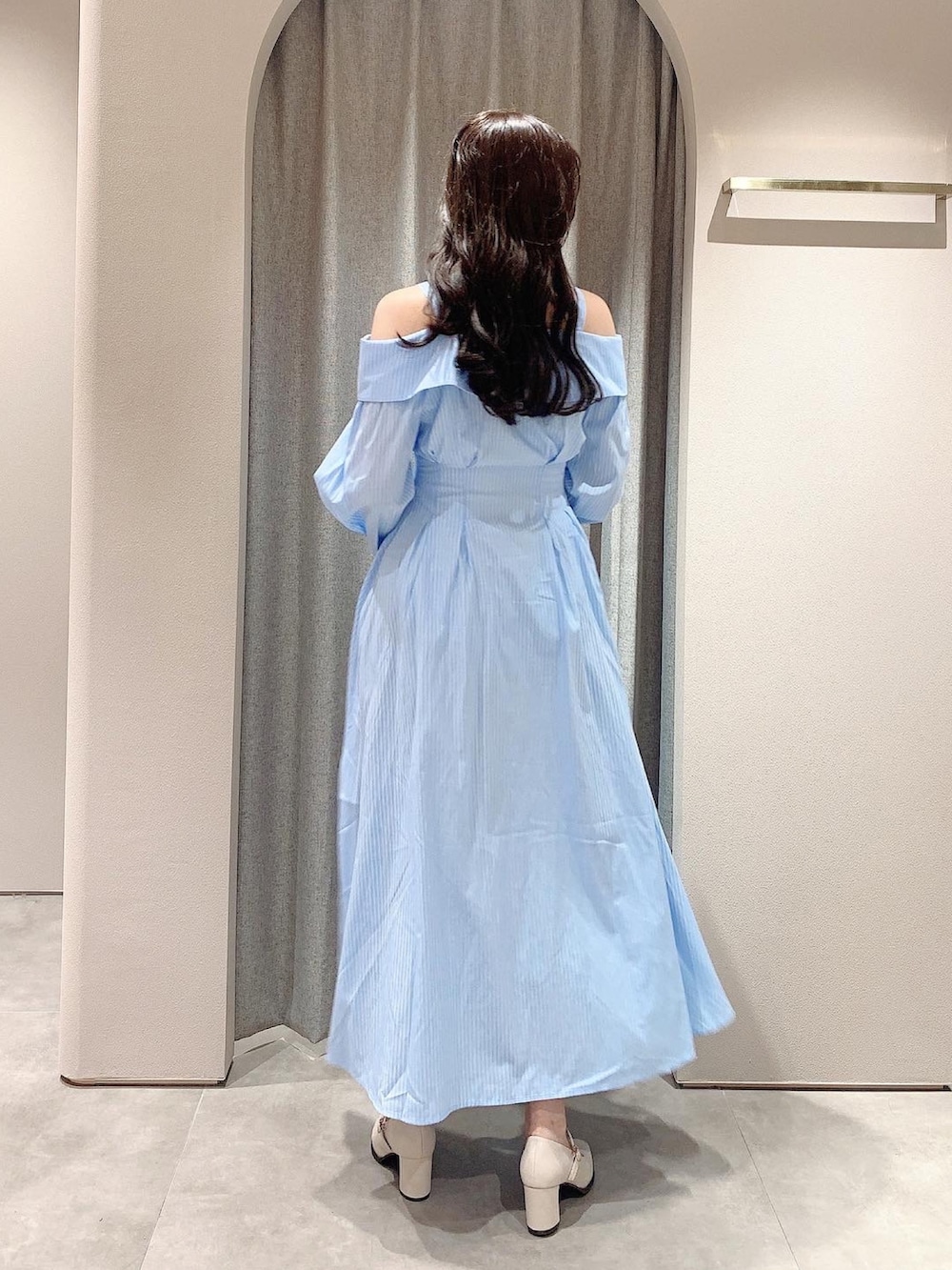 ブルー系のシャツワンピース、ホワイト系のテーラードジャケット、ホワイト系のパンプスを着用したレディースの冬コーディネートの5枚目の写真