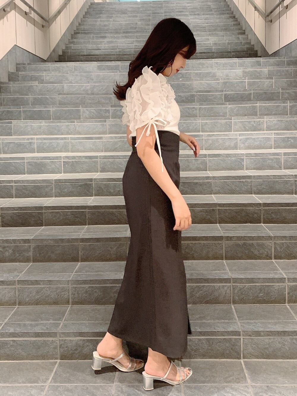 ブラウン系のスカート、シルバー系のパンプス、ホワイト系のTシャツ/カットソーを着用したレディースの夏コーディネートの4枚目の写真