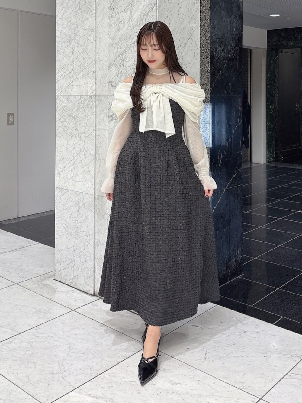 ブラック系のパンプス、ブラック系のドレスを着用したレディースの冬コーディネートの7枚目の写真