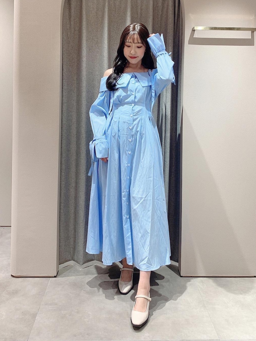 ブルー系のシャツワンピース、ホワイト系のテーラードジャケット、ホワイト系のパンプスを着用したレディースの冬コーディネートの3枚目の写真