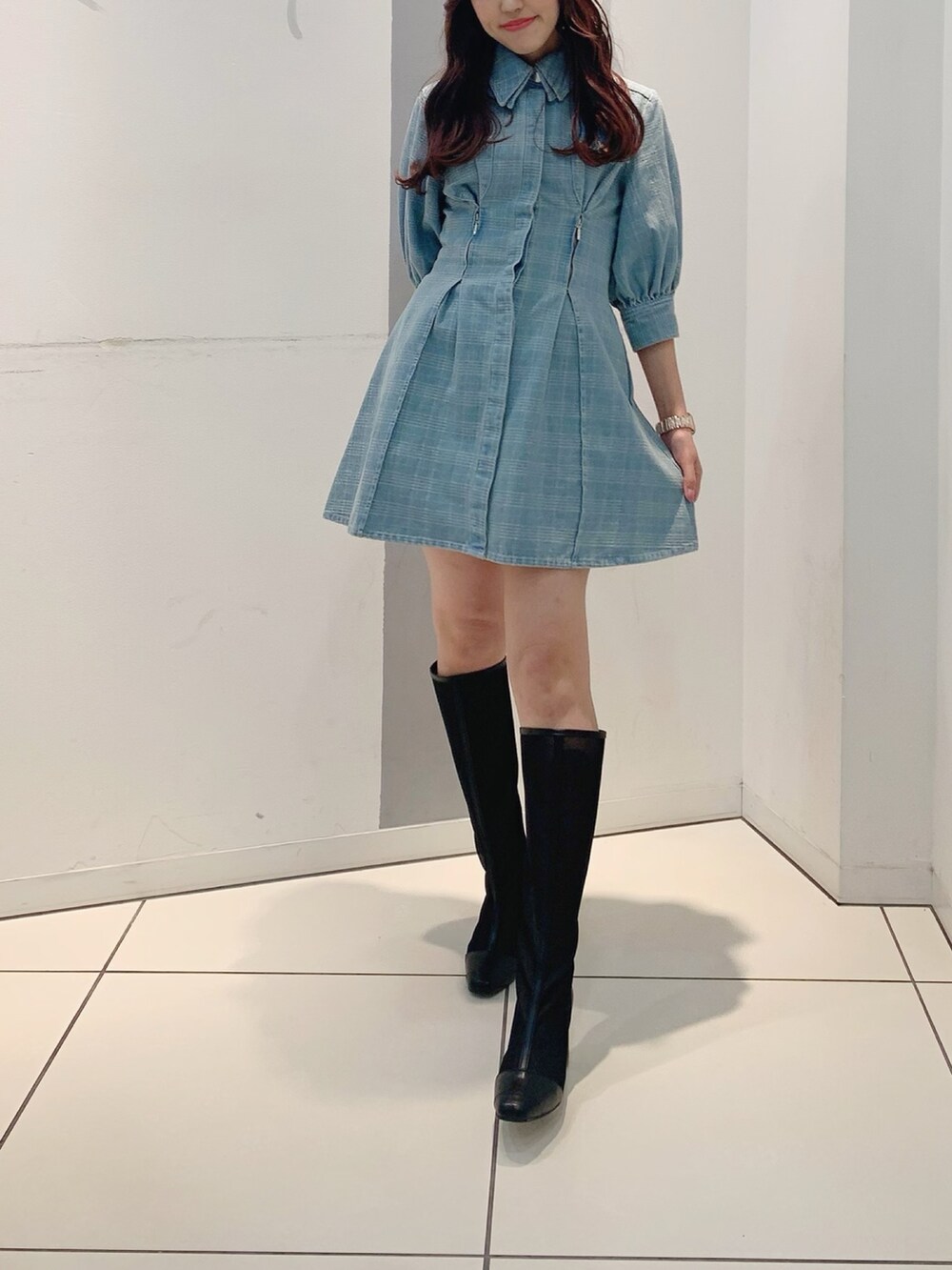 ブルー系のシャツワンピース、ブラック系のブーツを着用したレディースの冬コーディネートの3枚目の写真