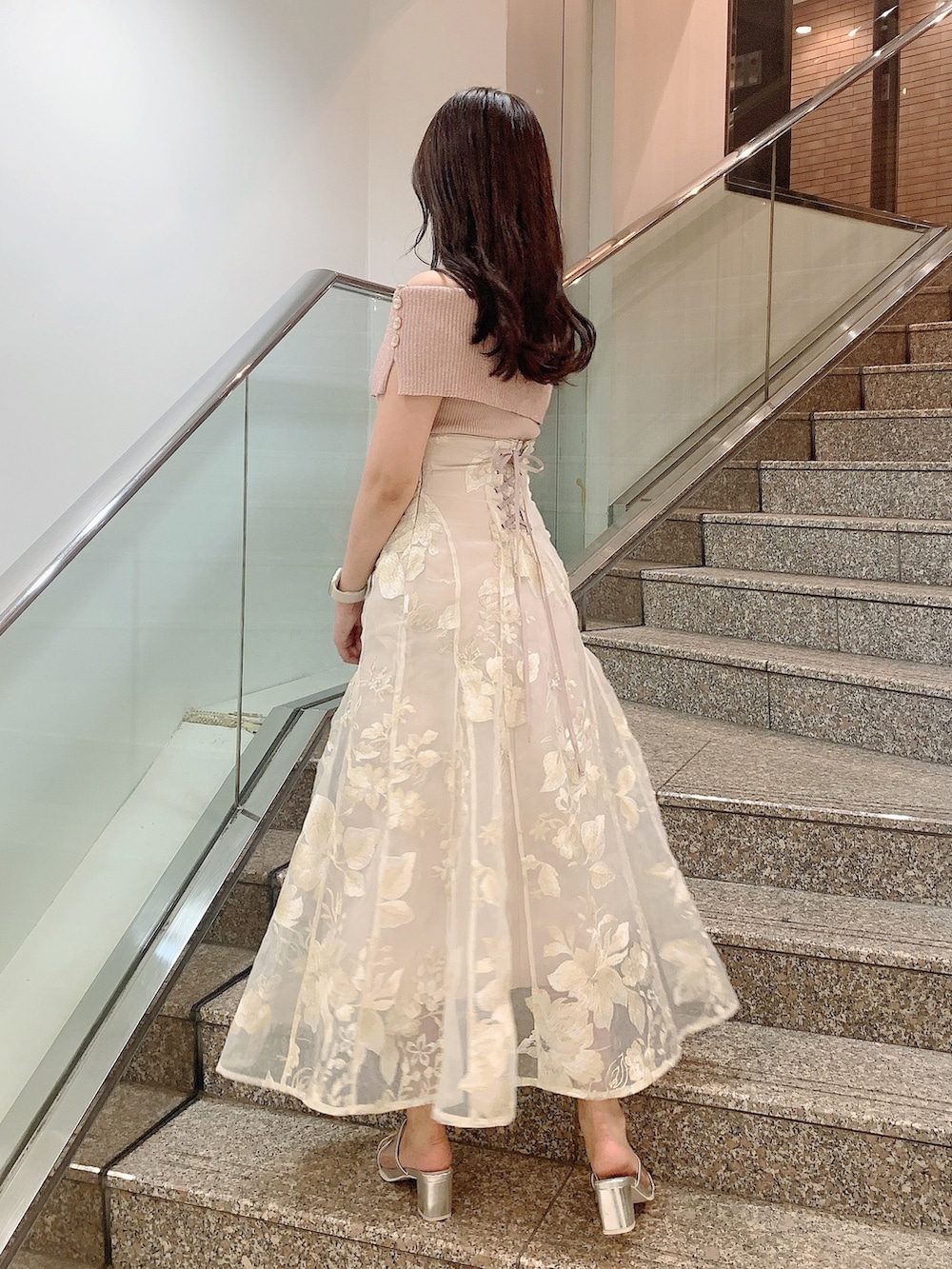 ベージュ系のスカート、ピンク系のニット/セーター、シルバー系のパンプスを着用したレディースの夏コーディネートの4枚目の写真