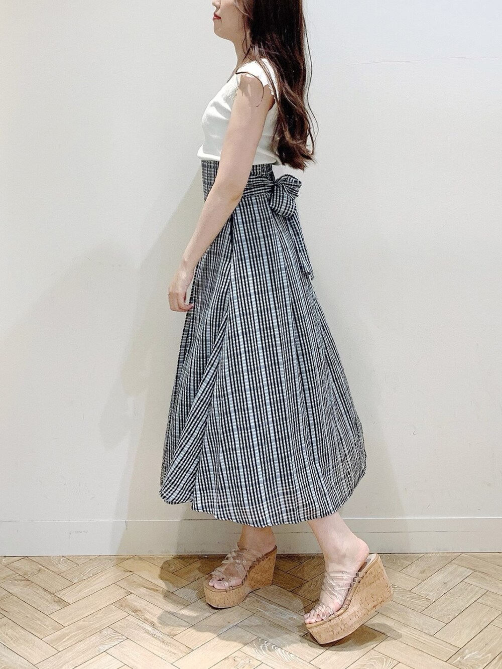 ブラック系のスカート、ホワイト系のニット/セーターを着用したレディースの夏コーディネートの3枚目の写真