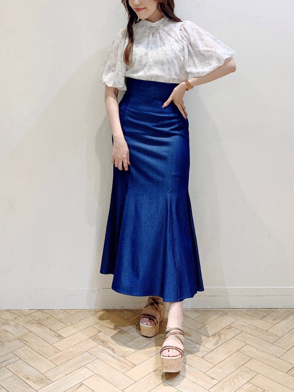 ブルー系のスカート、ベージュ系のシャツ/ブラウス、その他のサンダルを着用したレディースの夏コーディネートの3枚目の写真