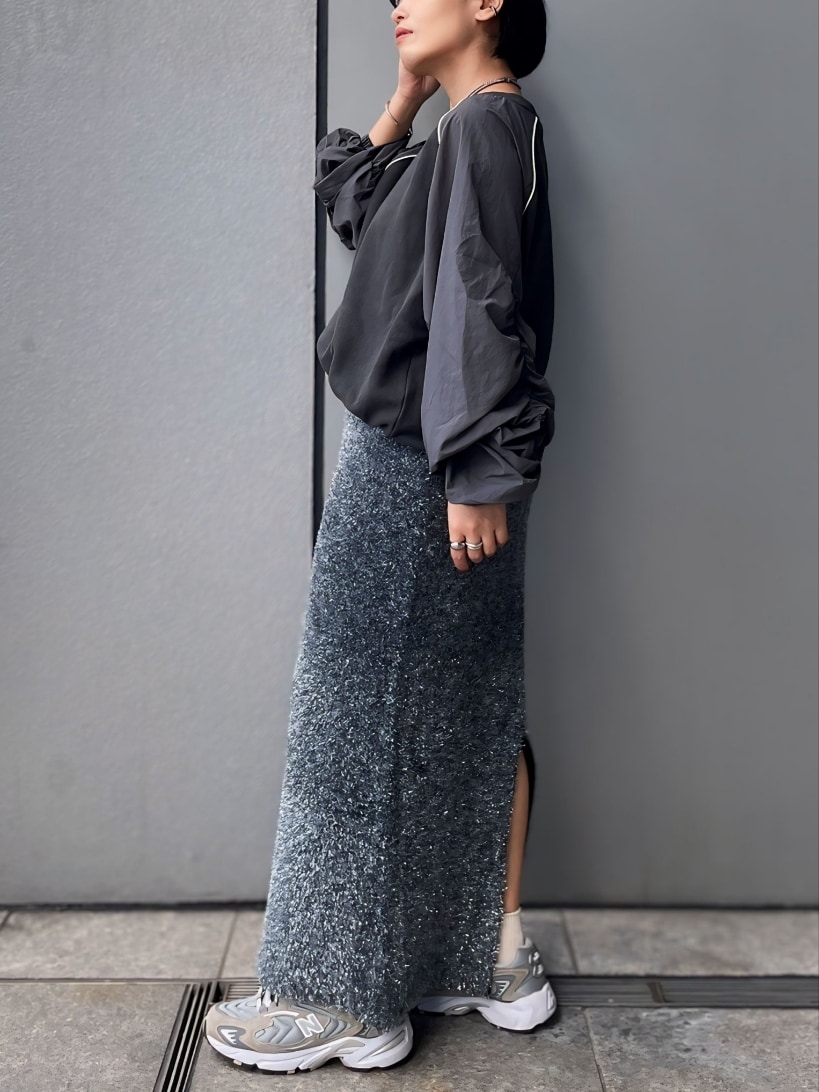 グレー系のスウェット、ブラック系のスカートを着用したレディースの秋コーディネートの3枚目の写真