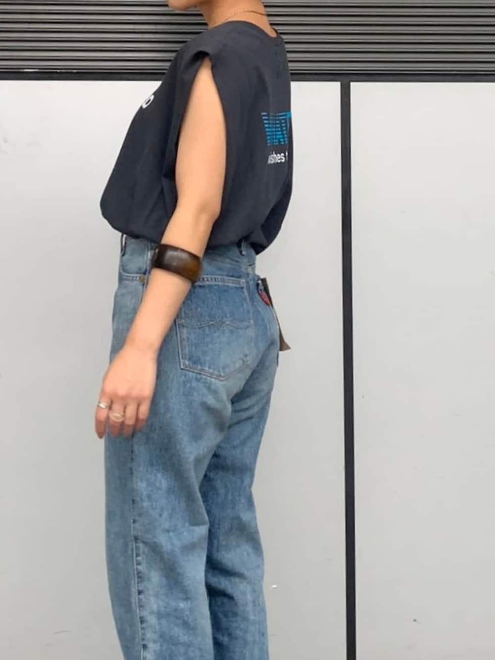 ブルー系のデニムパンツ、グレー系のタンクトップ、ブラウン系のブレスレットを着用したレディースの春コーディネートの5枚目の写真