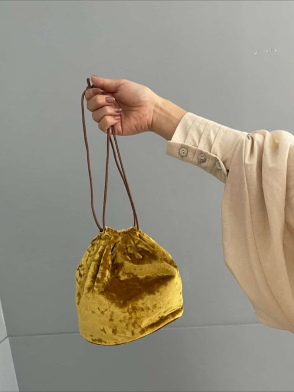 イエロー系のハンドバッグ、ブルー系のデニムパンツ、ホワイト系のシャツ/ブラウスを着用したレディースの夏コーディネートの3枚目の写真