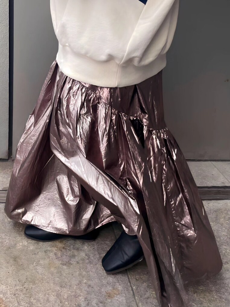 ホワイト系のパーカー、シルバー系のスカート、ブラック系のブーツを着用したレディースの冬コーディネートの4枚目の写真