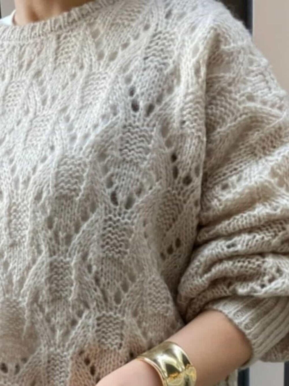 ベージュ系のデニムパンツ、ホワイト系のTシャツ/カットソー、ベージュ系のニット/セーターを着用したレディースの秋コーディネートの3枚目の写真