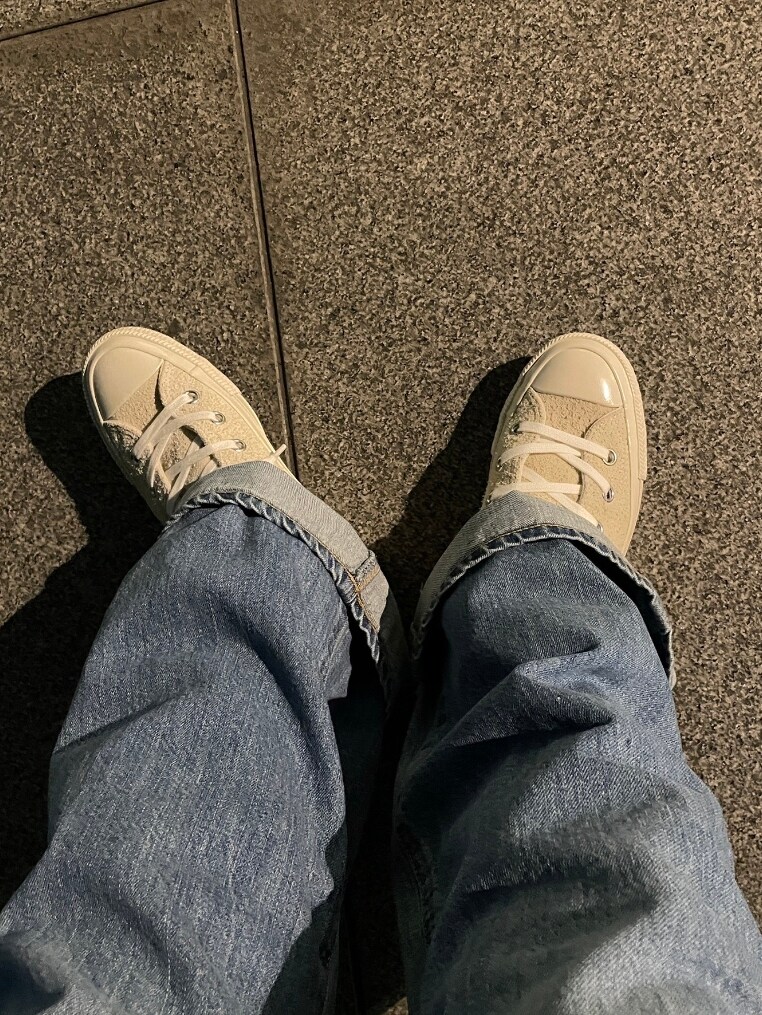 グレー系のTシャツ/カットソー、ホワイト系のスニーカー、ブルー系のデニムパンツを着用したレディースの春コーディネートの4枚目の写真