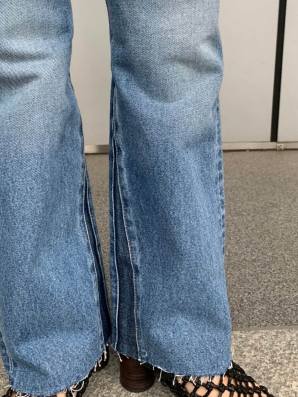 ブラック系のシャツ/ブラウス、ブラック系のサンダル、ブルー系のデニムパンツを着用したレディースの春コーディネートの3枚目の写真