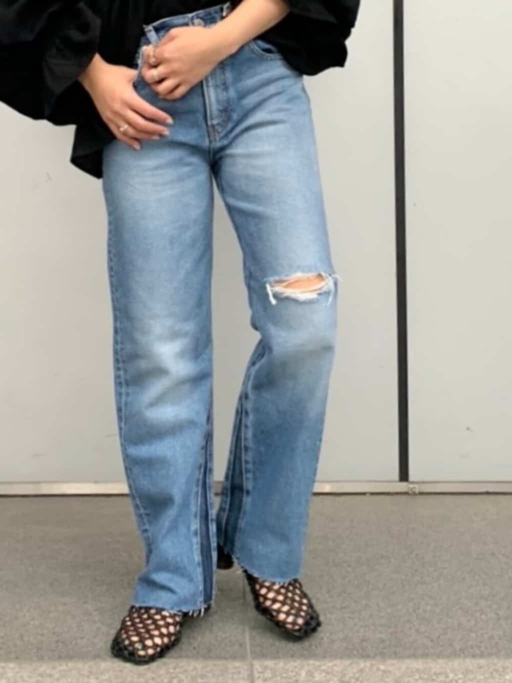 ブラック系のシャツ/ブラウス、ブラック系のサンダル、ブルー系のデニムパンツを着用したレディースの春コーディネートの2枚目の写真