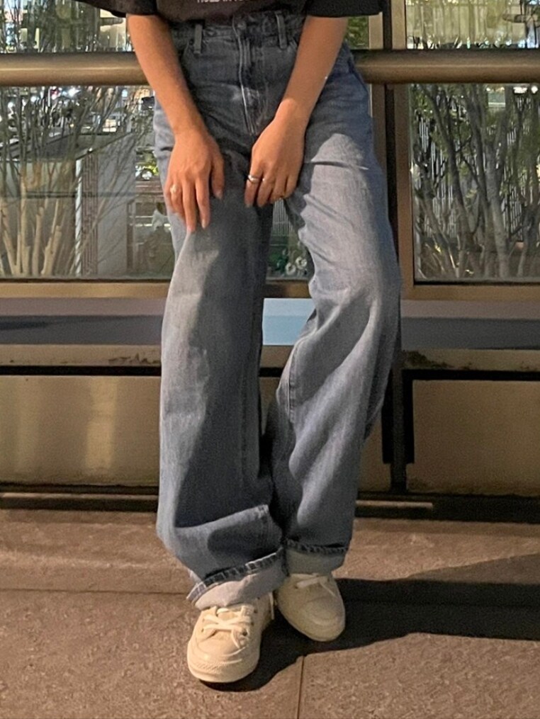 グレー系のTシャツ/カットソー、ホワイト系のスニーカー、ブルー系のデニムパンツを着用したレディースの春コーディネートの2枚目の写真