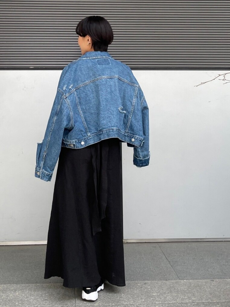 ブルー系のデニムジャケット、ブラック系のワンピース、ブラック系のスニーカーを着用したレディースの春コーディネートの3枚目の写真