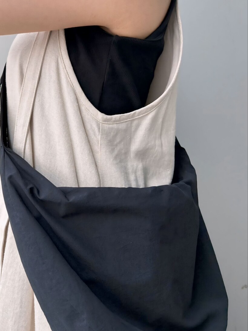 ホワイト系のワンピース、ブラック系のタンクトップ、ブラック系のショルダーバッグを着用したレディースの夏コーディネートの5枚目の写真