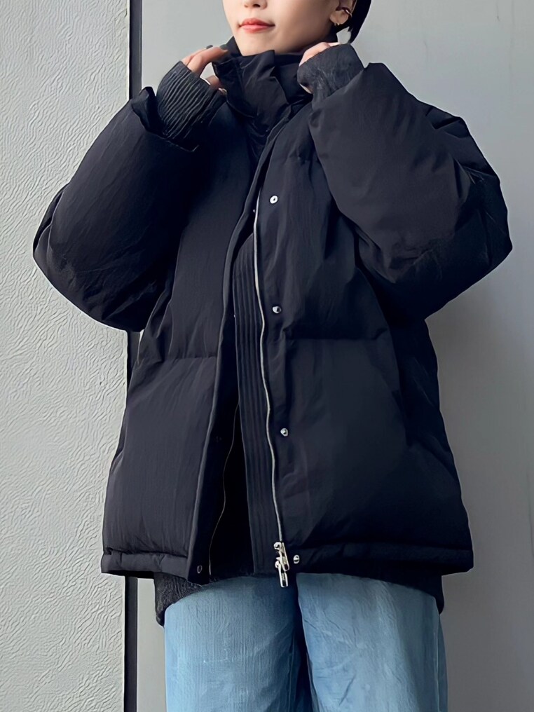 ブラック系のダウンジャケット/コート、ブルー系のデニムパンツを着用したレディースの秋コーディネートの3枚目の写真