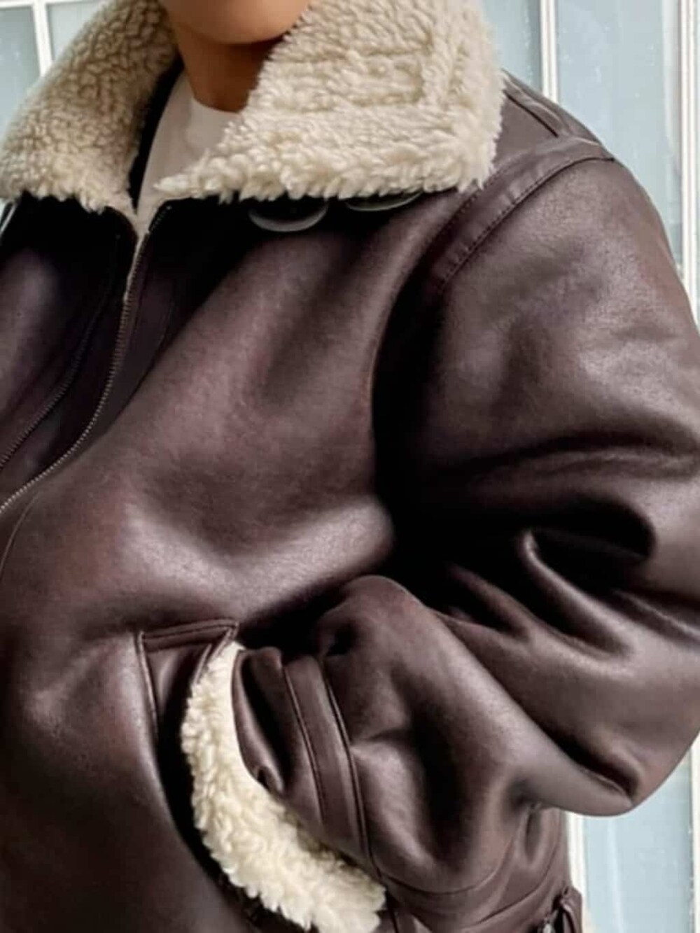 ホワイト系のTシャツ/カットソー、ブルー系のデニムパンツ、ブラウン系のブルゾンを着用したレディースの秋コーディネートの3枚目の写真